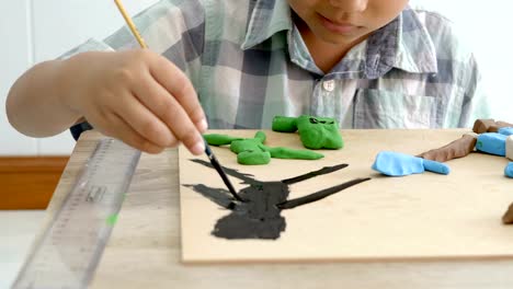 Child's-hands-playing-colorful-clay-and-paint-on-table.-Development-of-fine-motor-skills-of-fingers-and-creativity,-education