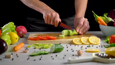 Man-is-cutting-vegetables-in-the-kitchen,-slicing-green-bell-pepper