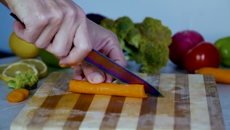 Man-is-cutting-vegetables-in-the-kitchen,-slicing-carrot