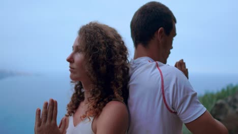 Hombre-y-la-mujer-sentada-encima-de-una-montaña-en-una-piedra-espalda-con-espalda,-meditan-y-hacen-yoga-en-el-fondo-del-océano.