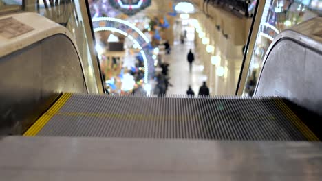 Escalator-in-the-mall-close-up.-In-the-background,-people-are-out-of-focus-for-shopping.