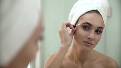 Beauty-Makeup.-Woman-Brushing-Eyebrows-At-Bathroom-Mirror