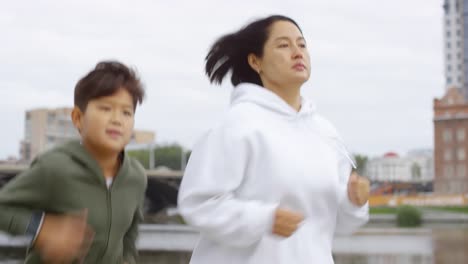 Familia-Deportiva-Corriendo-A-Lo-Largo-De-La-Ribera-Urbana.