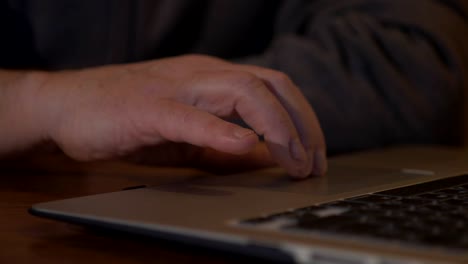 Abuelo-sentado-en-un-escritorio-y-trabajar-en-un-ordenador-portátil.-Está-escribiendo.