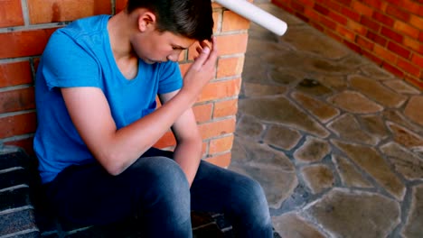 Sad-schoolboy-sitting-alone-on-staircase