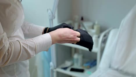 Beautician-putting-on-rubber-glove-on-her-hand.