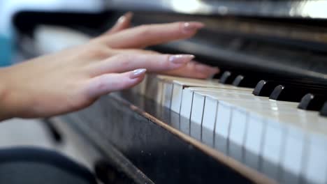 Female-hand-gently-touches-piano-keys
