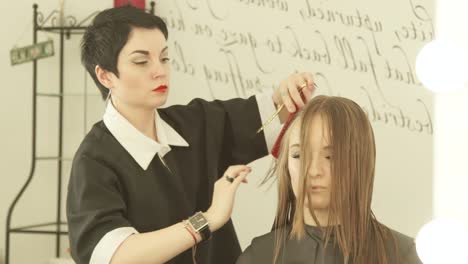 Woman-hairstylist-cutting-long-hair-with-scissors-in-hairdressing-salon.-Close-up-haircutter-making-female-haircut-with-scissors-in-beauty-salon