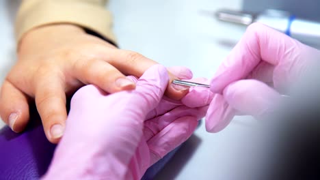 Beautician-careful-and-accurate-removing-cuticles-with-polish-machine