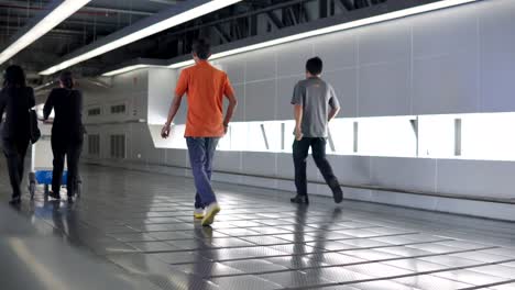 Passengers-walking-through-walkway-corridor-to-the-terminal-building-at-Suvarnabhumi-international-airport-.-4K-video