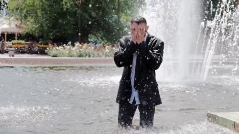 A-man-is-walking-in-a-fountain,-covering-his-face-with-hands-and-feeling-all-the-sadness-in-the-world