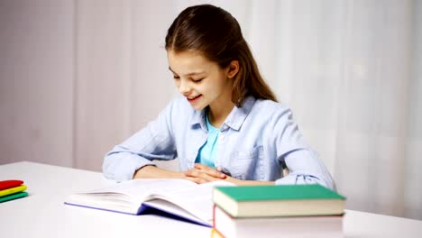 happy-school-girl-reading-book-or-textbook-at-home