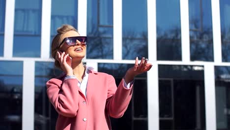 Young-female-in-stylish-coat-explaining-something-on-the-smart-phone