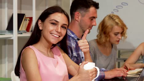 Glücklich-schöne-Studentin-zeigt-Daumen-nach-oben