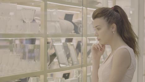 Woman-choose-the-goods-look-at-shop-window-in-mall