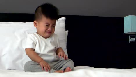 Baby-boy-crying-on-the-white-bed,-Slow-motion