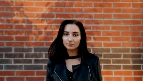 Young-charming-woman-straightens-her-hair-and-looks-at-the-camera-with-a-serious-look.