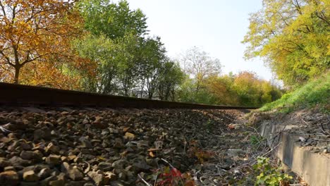 Eisenbahnschienen-Blick-ein-Blick-von-der-Strecke-aus-dem-Boden-während-der-Bewegung-langsam-nach-vorne-in-der-Nähe-der-lokalen-Gesamtstruktur-an-einem-sonnigen-Tag-am-Ende-des-Herbstes.