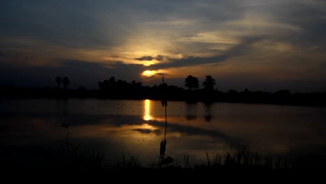 The-sun-rises-over-mountains-and-a-body-of-water.