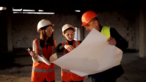 The-engineer-communicates-with-the-female-customer-representatives-at-the-construction-site,-checking-the-drawings-with-the-actual-progress-of-construction-work
