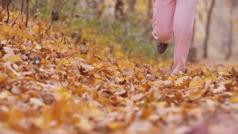 Macro-shoot-of-woman-running-in-autumn-landscape-in-super-slow-motion