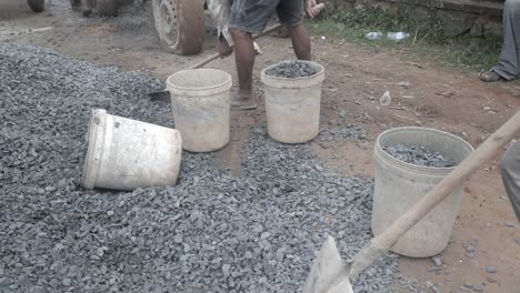 Using-a-shovel-to-put-gravel-into-a-bucket-(-close-up)