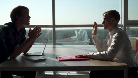 Two-men-have-discussion-in-the-big-office