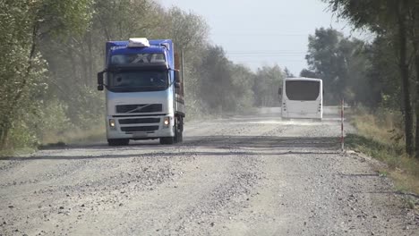 Industrial-dumper-trucks-working-on-highway-construction-site,-loading-and-unloading-gravel-and-earth.-heavy-duty-machinery-activity