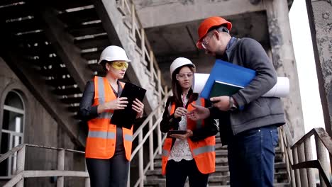 The-foreman-and-two-women-inspectors-to-discuss-the-plan-of-work-performed-on-construction-or-restoration-of-the-building.