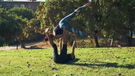 Schönes-paar-praktizieren-Acro-Yoga-am-Morgen