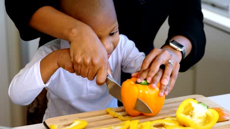 Madre-e-hijo-cortando-verduras-en-la-cocina-en-casa-4k