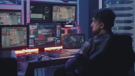 Hacker-watching-multiple-monitors