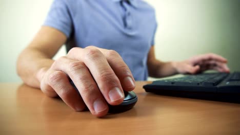 Close-up-of-hands-typing-on-computer-keyboard-and-mouse