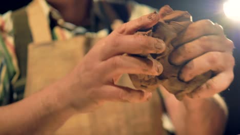 A-low-view-on-potters-fingers-pressing-into-clay-to-knead-it.