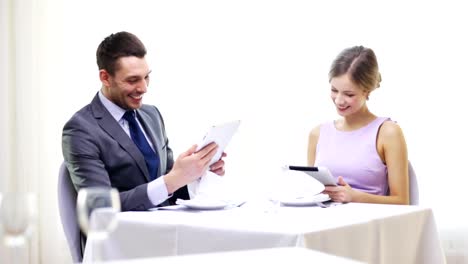 couple-with-menus-on-tablet-pc-at-restaurant