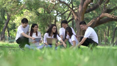 Reunión-de-seis-estudiantes-haciendo-la-tarea-juntos.-Equipo-de-la-reunión-de-personas-en-el-parque-al-aire-libre.-Hombre-y-mujer-con-ordenador-portátil.-Concepto-de-educación,-trabajo-en-equipo,-aprendizaje,-información,-conocimiento-e-investigación.