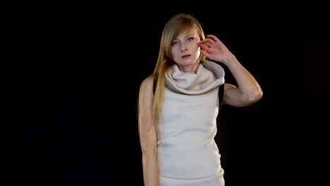 blonde-model-of-European-appearance-posing-in-front-of-camera-in-studio-on-black-background