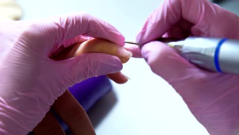 Beautician-careful-and-accurate-removing-cuticles-with-polish-machine