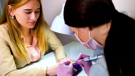 Beautician-careful-and-accurate-removing-cuticles-with-polish-machine