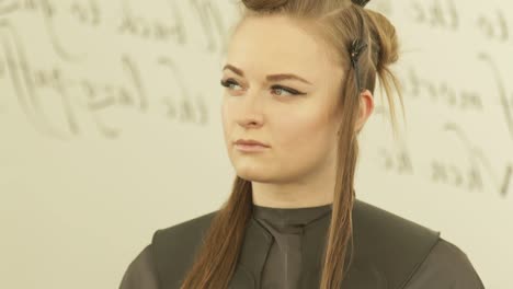 Face-young-woman-with-clamp-on-hair-during-haircutting-in-hairdressing-salon-close-up.-Female-hair-model-in-beauty-studio