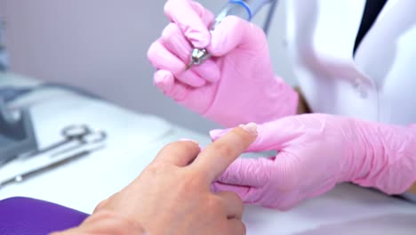 Beautician-careful-and-accurate-removing-cuticles-with-polish-machine