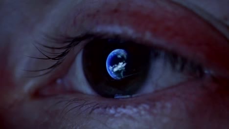 Close-up-of-woman's-eye-with-the-earth-reflecting-in-the-iris