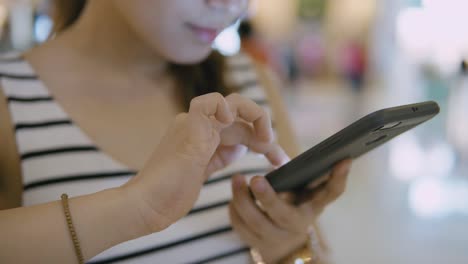 Woman-using-mobile-phone-in-the-mall