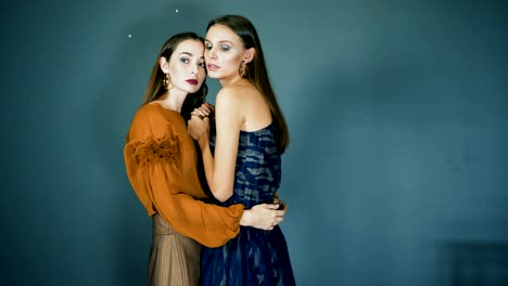 presentation-of-collection,-models-together-with-bright-makeup-close-up-posing-on-camera-on-dark-blue-background