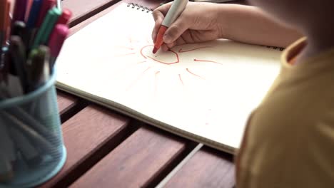 Children-homework-close-up.-Young-mixed-race-boy-doing-homework-in-terrace-at-home.-Drawing-and-writing.-Focus-mood.-Back-to-school-concept.