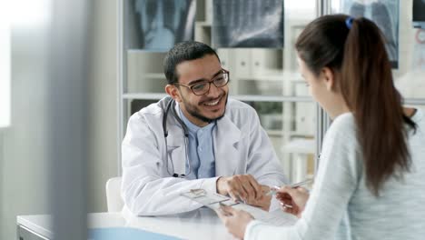 Lächelnde-Arzt-im-Gespräch-mit-der-Patientin