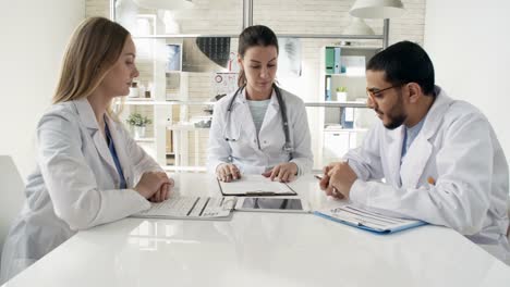 Multiethnic-Doctors-Discussing-Documents-at-Meeting