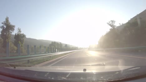 Auto-auf-der-Autobahn-im-Sonnenaufgang-Sonne,-POV-Frontscheibe,-Lens-flare