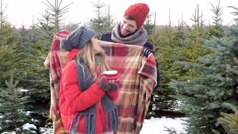 Couple-with-blanket-in-winter-forest