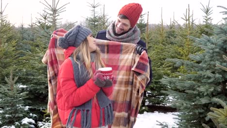 Pareja-con-manta-en-bosque-del-invierno